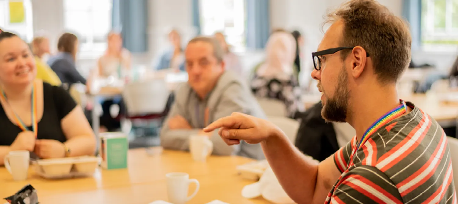 Three people seated at a table, engaged in a discussion.