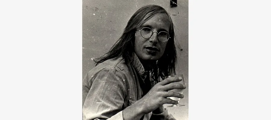 Black and white photo of David Gothard holding a drink.