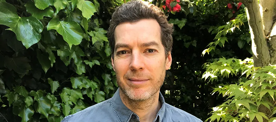 Dominic Sutherland headshot with leaves in the background