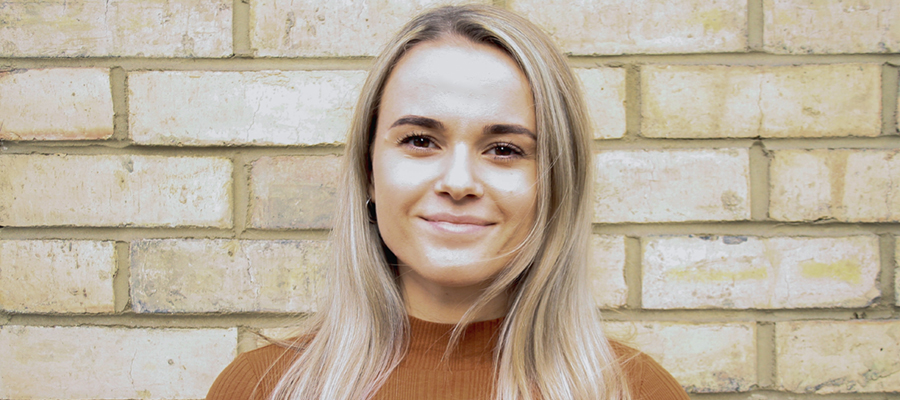 Erin Bertram standing in front of a brick wall