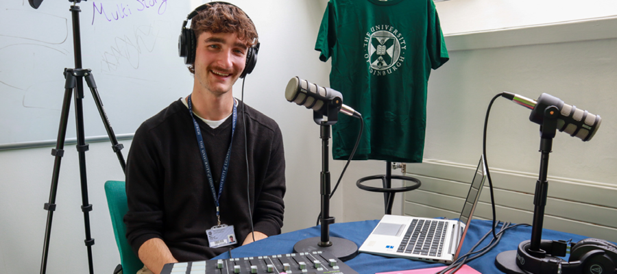 Photo of Matt O'Malley in a recording studio wearing headphones and smiling.