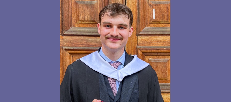 Toby in his graduation gown smiling.