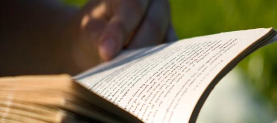 A hand holding open book