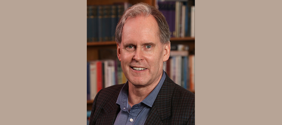 Robert Morrison in front of a bookshelf